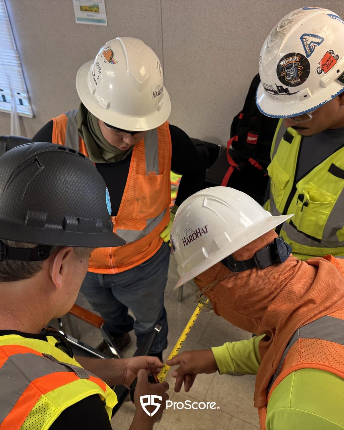 A crew in hard hats and hi-vis gathered around an on-site, hands-on training session